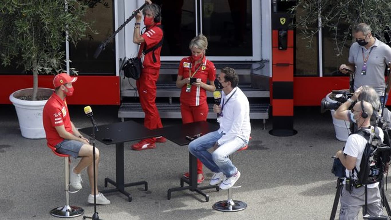 Sebastian Vettel (l) von der Scuderia Ferrari wird auf der Rennstrecke von Mugello interviewt.