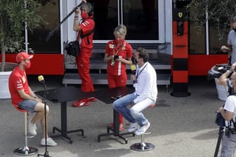 Sebastian Vettel (l) von der Scuderia Ferrari wird auf der Rennstrecke von Mugello interviewt.