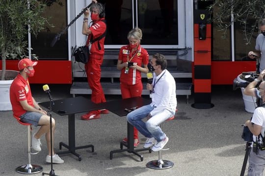 Sebastian Vettel (l) von der Scuderia Ferrari wird auf der Rennstrecke von Mugello interviewt.