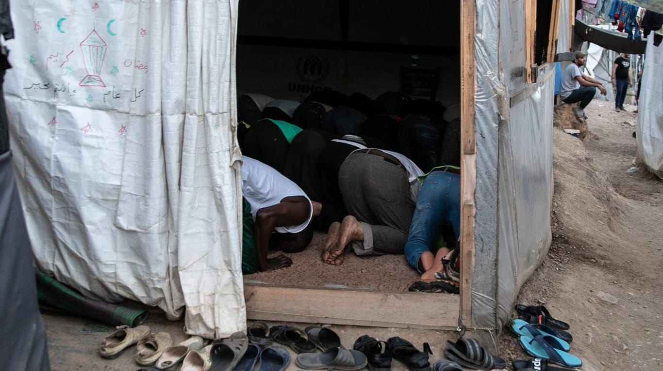 Das Flüchtlingslager Samos im Jahr 2019: Eine Gruppe muslimischer Geflüchteter betet in einem Container.