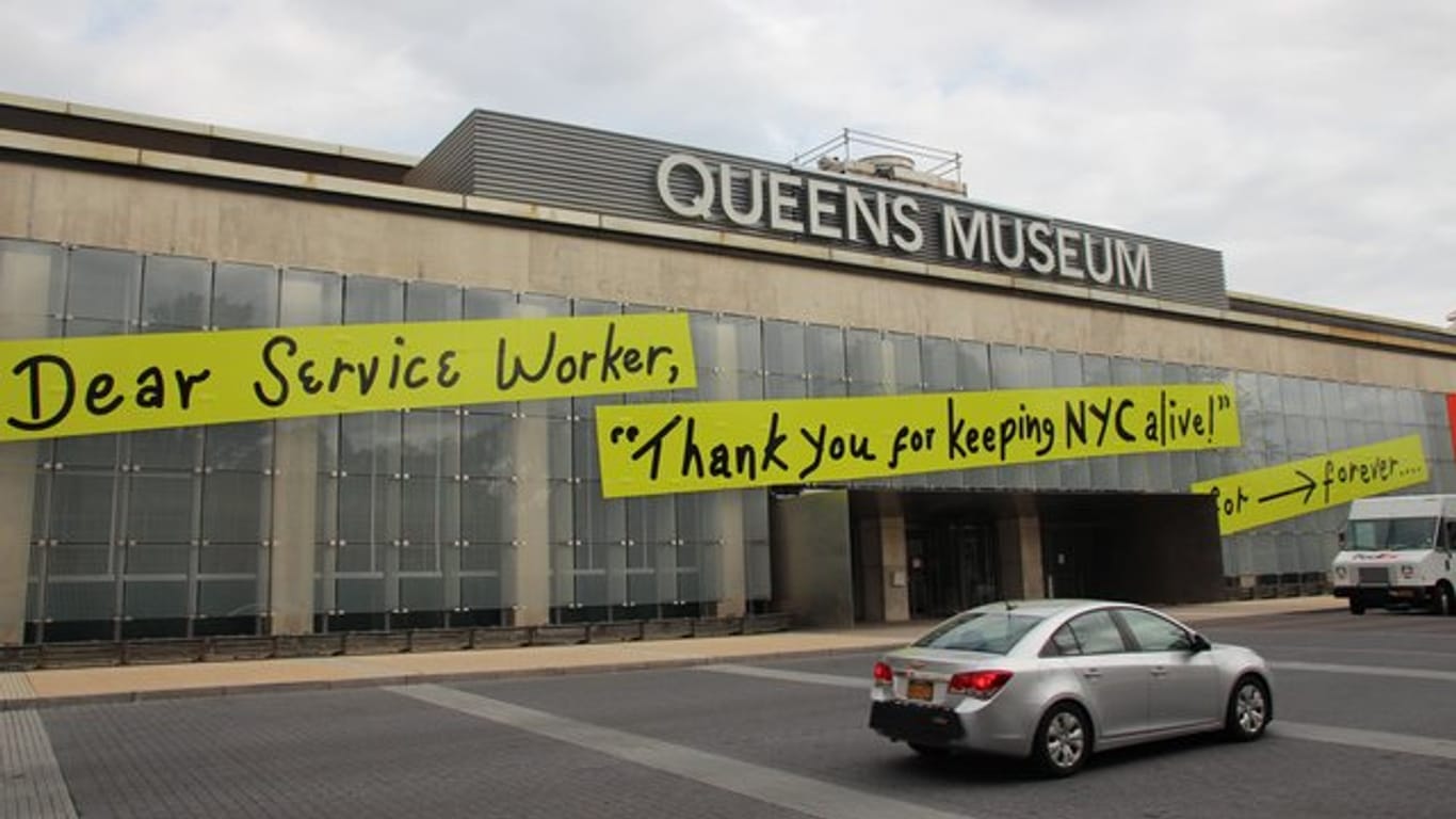 Auf dem Queens Museum steht auf angebrachten Transparenten "Dear Service Worker, "Thank you for keeping NYC alive!".
