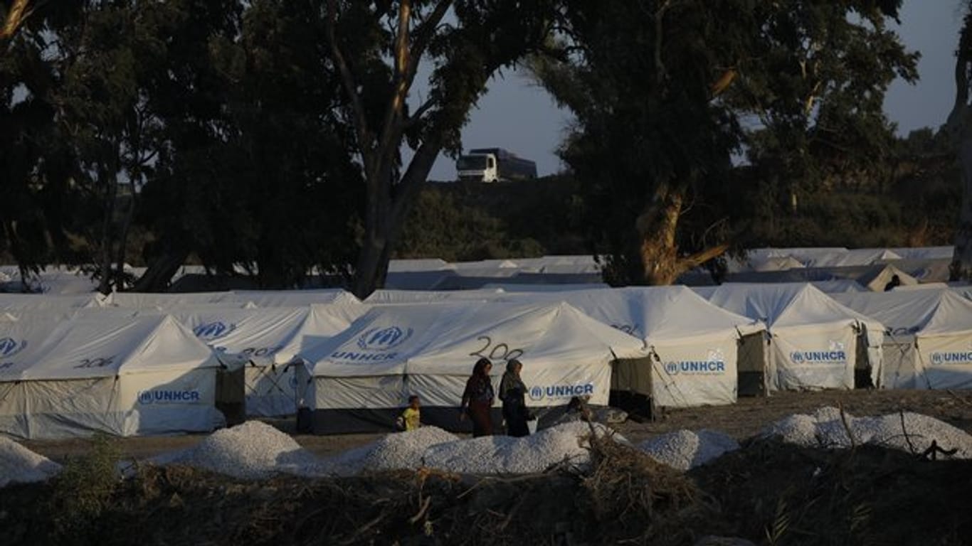 Migranten vor neuen Zelten in einem provisorischen Lager in der Nähe der Inselhauptstadt Mytilini.