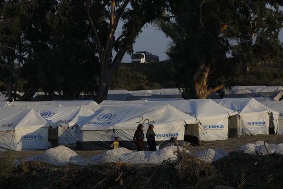 Migranten vor neuen Zelten in einem provisorischen Lager in der Nähe der Inselhauptstadt Mytilini.