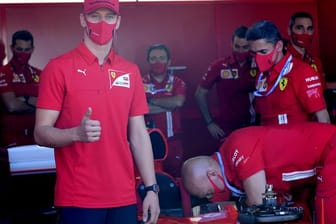 Mick Schumacher (l) besucht die Box von Ferrari.