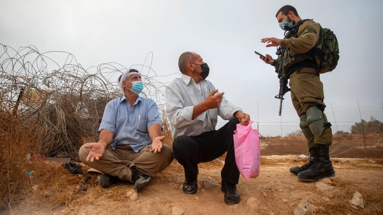 Ein israelischer Soldat und zwei Palästinenser: Noch immer ist das Verhätlnis stark belastet.