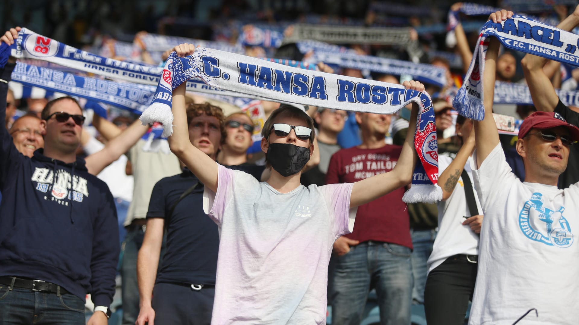 1. Runde im DFB-Pokal: Fußballfans des FC Hansa Rostock stehen auf den Tribünen im Ostseestadion.