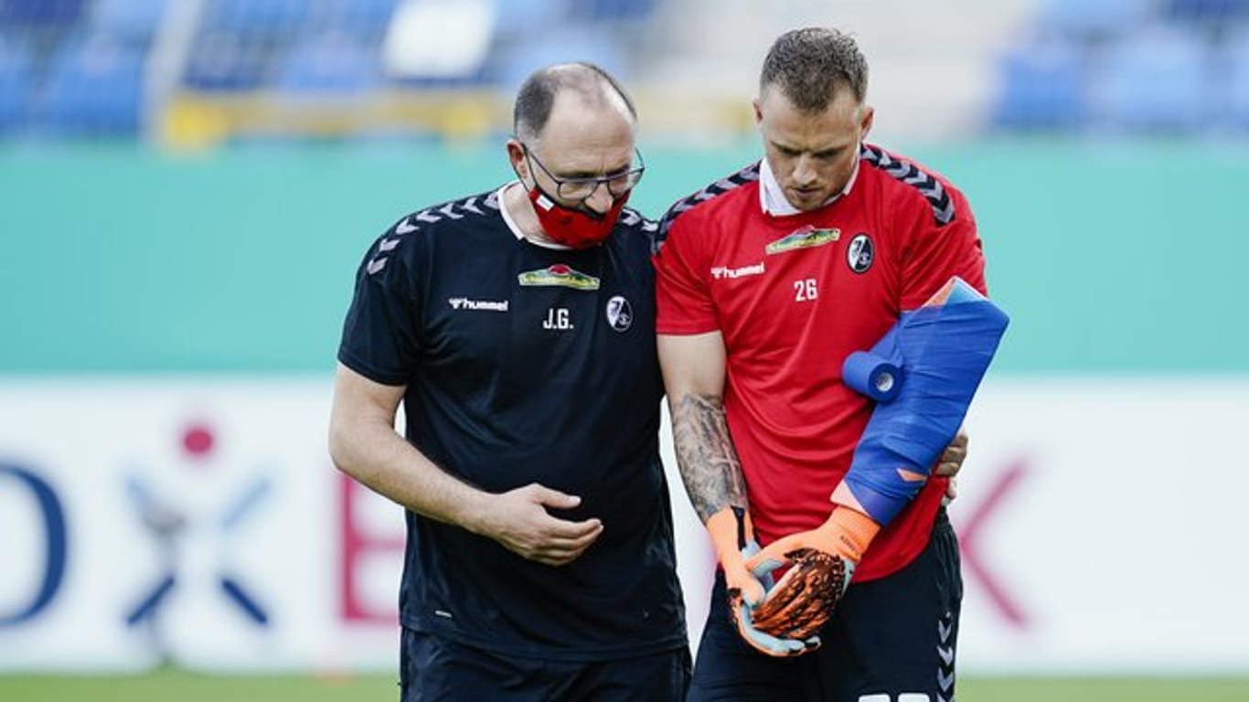 Freiburgs Torwart Mark Flekken (r) hat sich beim Aufwärmen vor der Pokalpartie gegen Mannheim am Arm verletzt.