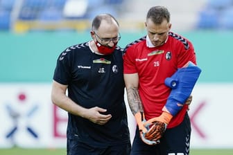 Freiburgs Torwart Mark Flekken (r) hat sich beim Aufwärmen vor der Pokalpartie gegen Mannheim am Arm verletzt.