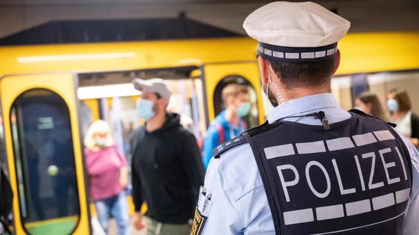 Polizeibeamte in Stuttgart kontrollieren an einer Haltestelle im öffentlichen Nahverkehr die Einhaltung der Maskenpflicht.