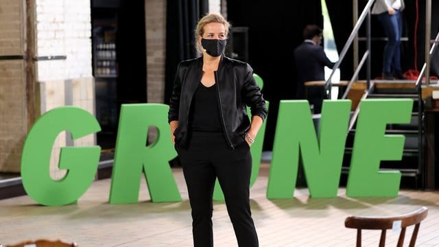 Mona Neubaur steht vor dem Logo der Partei Mona Neubaur steht vor dem Logo der Partei