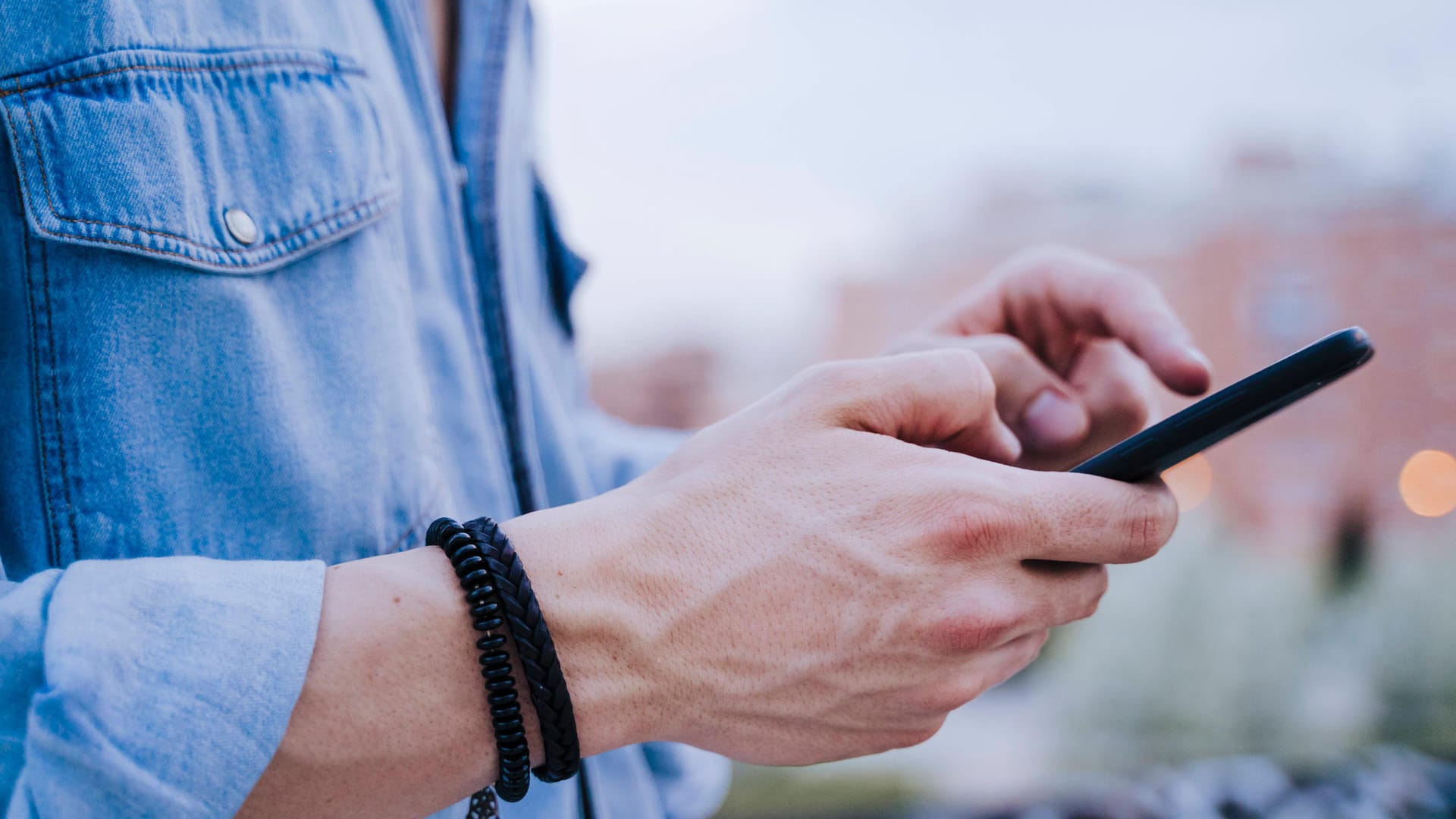 Ein Mann am Smartphone (Symbolbild): Die EU-Kommission startet einen Testlauf für den Datenaustausch verschiedener Corona-Warn-Apps.