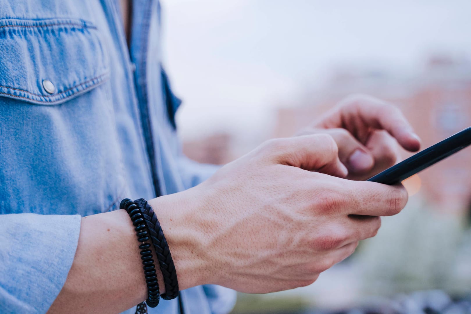 Ein Mann am Smartphone (Symbolbild): Die EU-Kommission startet einen Testlauf für den Datenaustausch verschiedener Corona-Warn-Apps.