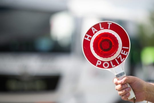 Polizist hält eine Polizeikelle