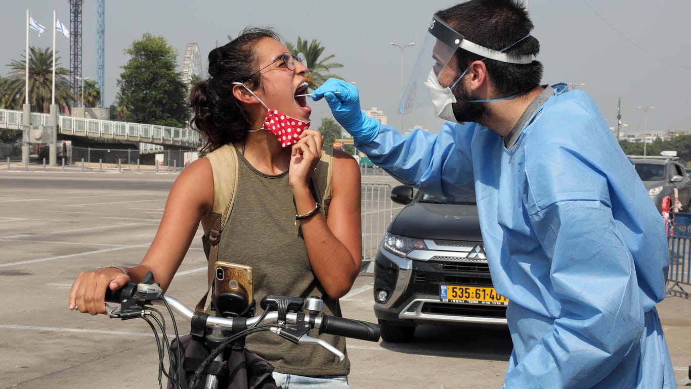 Tel Aviv: Medizinisches Personal testet Menschen auf der Straße auf Corona. Nach einem massiven Anstieg der Neuinfektionen, hat die israelische Regierung erneut einen Lockdown beschlossen.