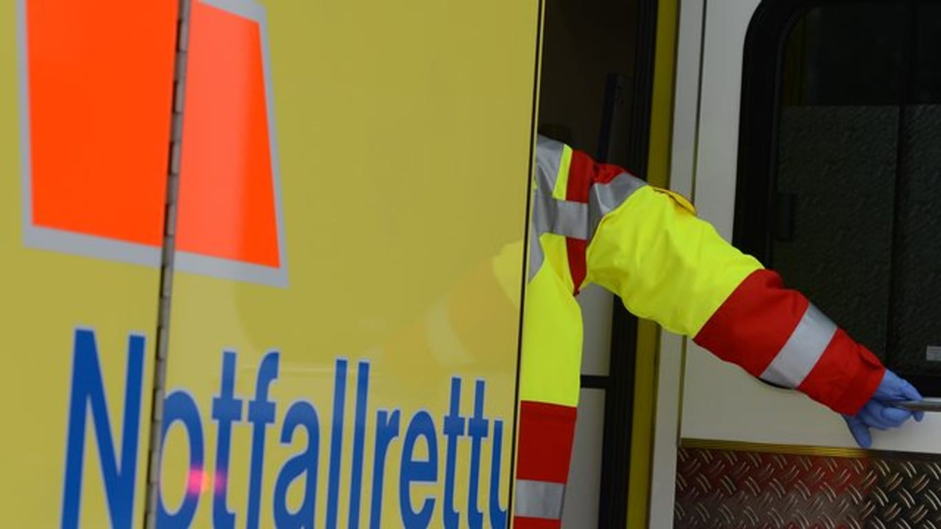 Ein Rettungsassistent steigt in einen Rettungswagen (Symbolbild): Bei einem Unfall in Hamburg wurden zwei Personen leicht verletzt.