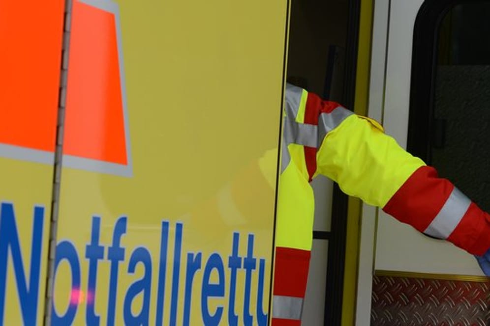 Ein Rettungsassistent steigt in einen Rettungswagen (Symbolbild): Bei einem Unfall in Hamburg wurden zwei Personen leicht verletzt.