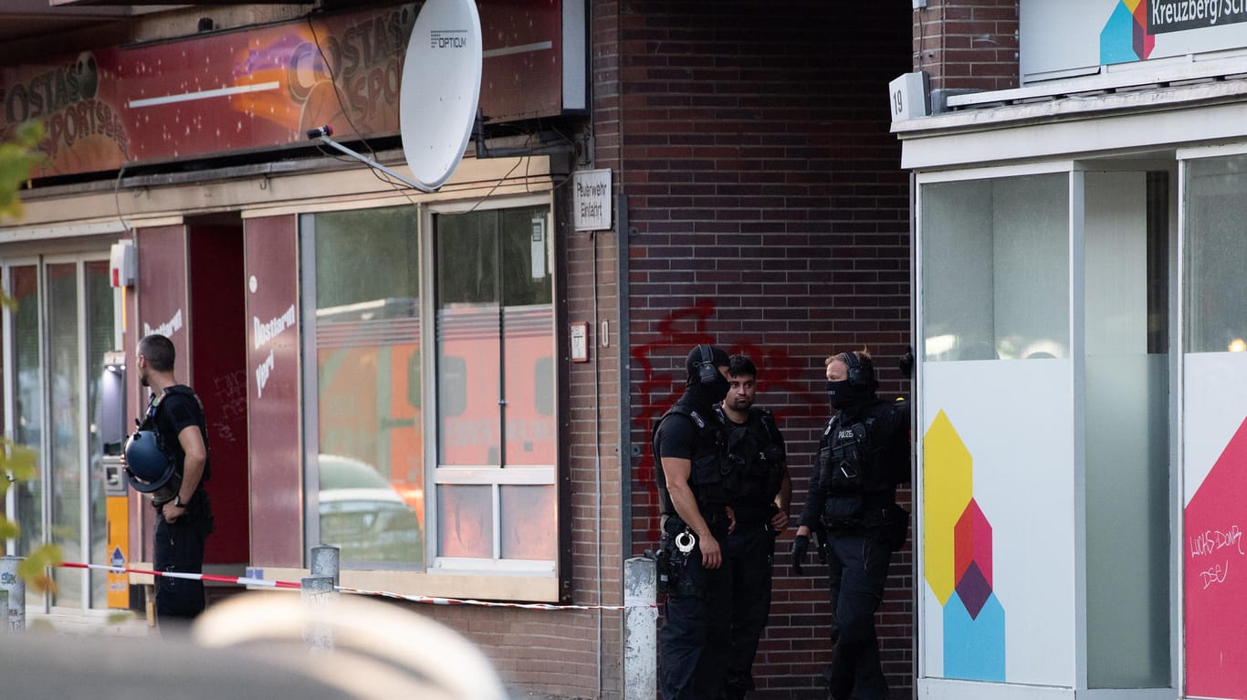 Polizeibeamte stehen in einer Einfahrt eines Gebäudekomplexes an der Goebenstraße in Berlin-Schöneberg: Dort ist ein Mann durch Schüsse verletzt worden.