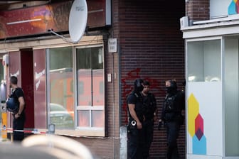 Polizeibeamte stehen in einer Einfahrt eines Gebäudekomplexes an der Goebenstraße in Berlin-Schöneberg: Dort ist ein Mann durch Schüsse verletzt worden.