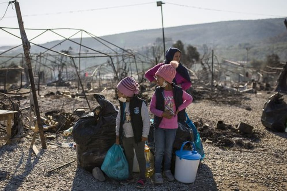 Eine Familie steht vor dem abgebrannten Flüchtlingslager Moria: Viele Menschen auf Lesbos sind nun obdachlos.