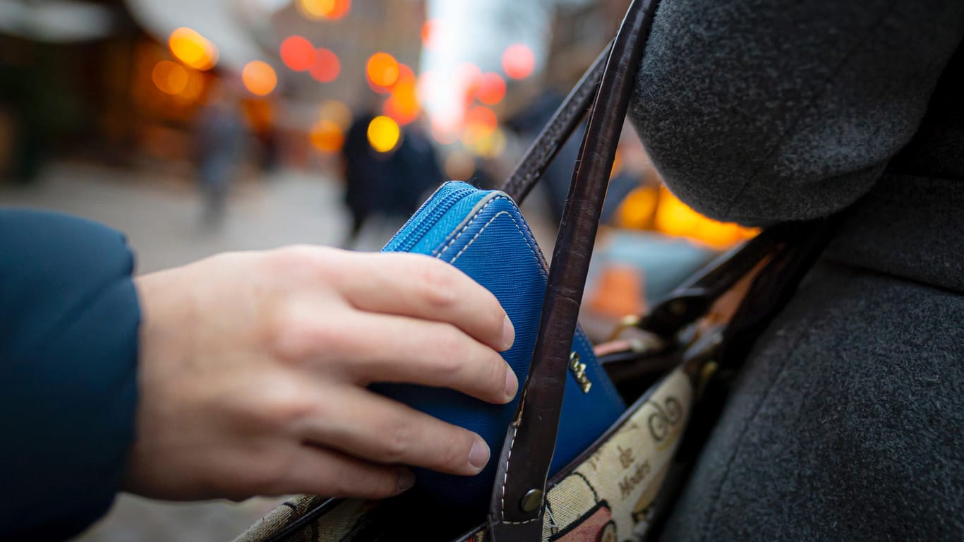 Eine Hand zieht ein Portemonnaie aus einer Handtasche (Symbolbild): In Hagen sind drei Frauen auf Diebestour gegangen.