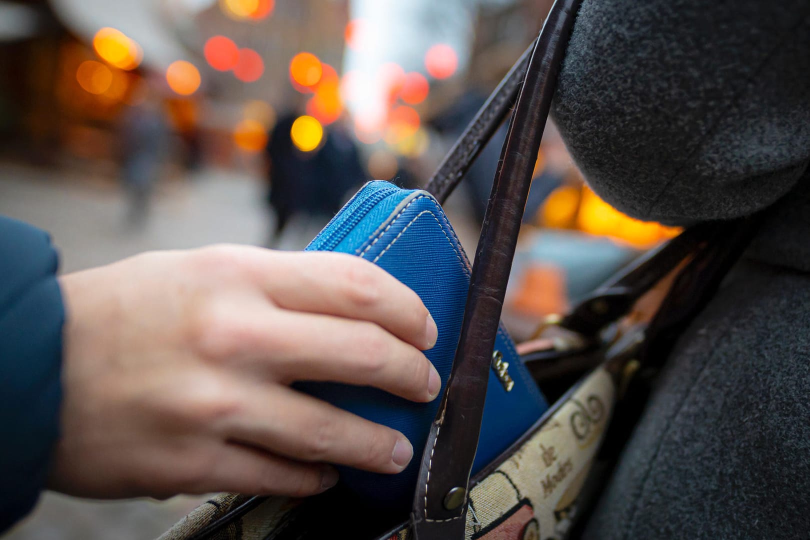 Eine Hand zieht ein Portemonnaie aus einer Handtasche (Symbolbild): In Hagen sind drei Frauen auf Diebestour gegangen.