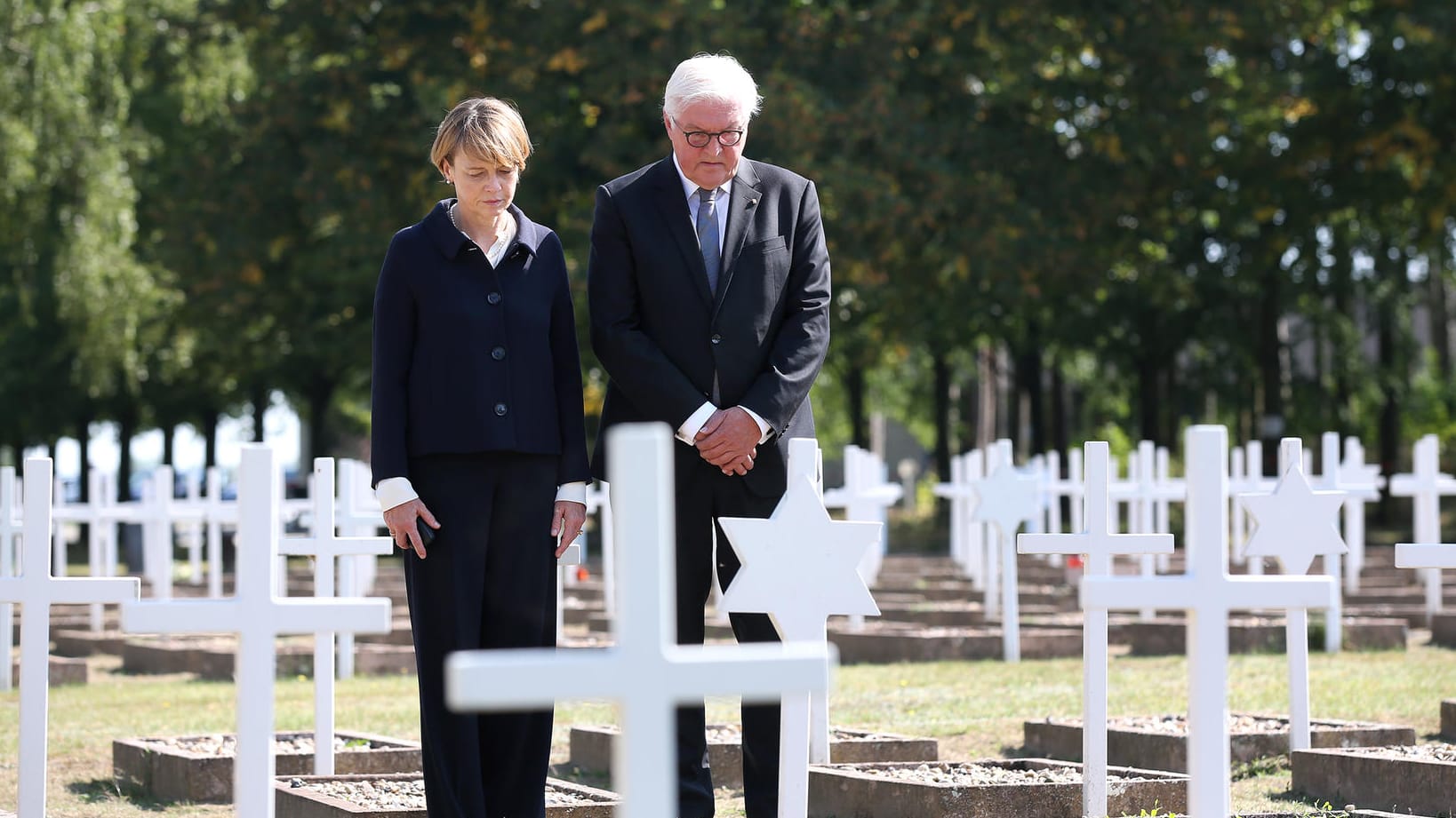 Sachsen-Anhalt, Gardelegen: Bundespräsident Frank-Walter Steinmeier und seine Ehefrau Elke Büdenbender stehen beim Stillen Gedenken auf dem Militärischen Ehrenfriedhof in der Gedenkstätte Feldscheune Isenschnibbe in Gardelegen.