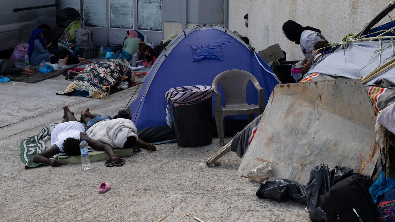 Griechenland, Lesbos: Migranten schlafen neben einem Zelt in der Nähe der Stadt Mytilene an der nordöstlichen Seite der Insel Lesbos. Viele weigern sich, in das Ersatzlager zu ziehen.