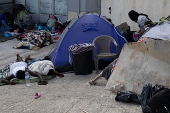 Griechenland, Lesbos: Migranten schlafen neben einem Zelt in der Nähe der Stadt Mytilene an der nordöstlichen Seite der Insel Lesbos. Viele weigern sich, in das Ersatzlager zu ziehen.