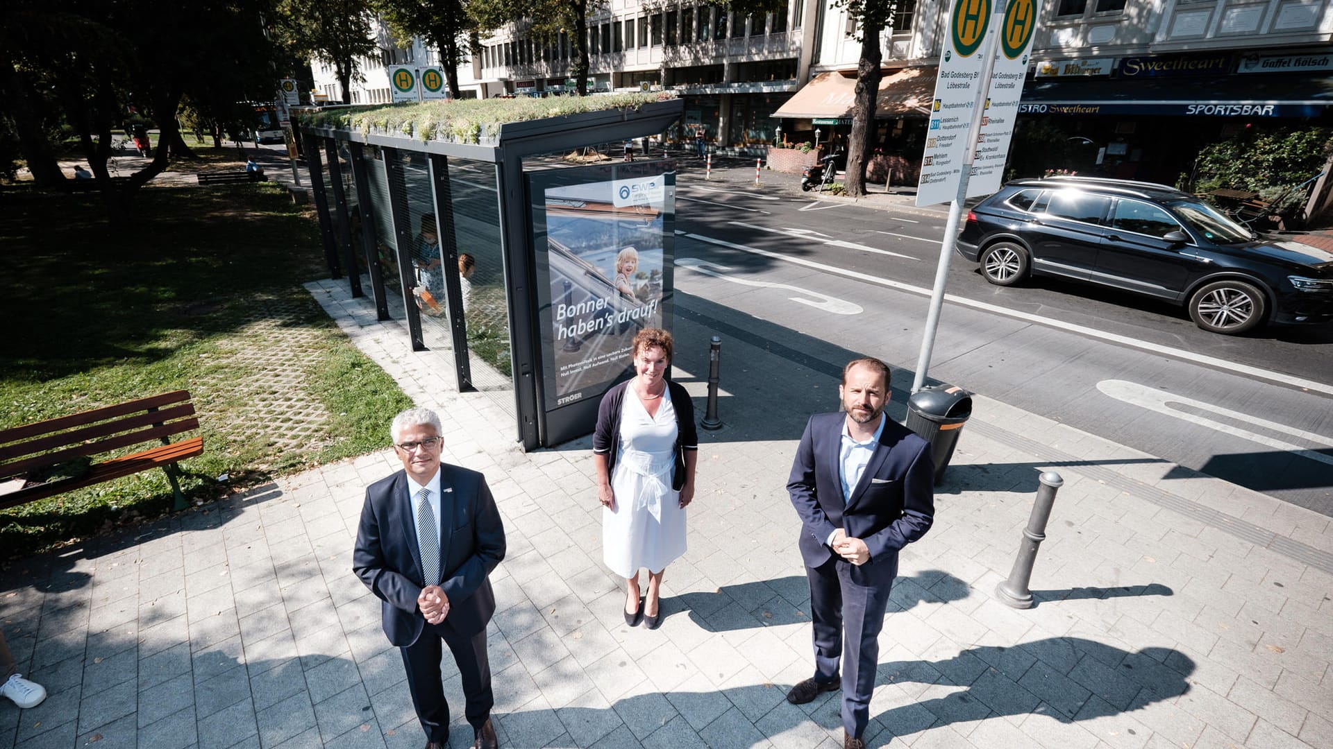Das neu begrünte Bushäuschen an der Haltestelle Bad Godesberg Bahnhof mit OB Ashok Sridharan, Anja Wenmakers von den Stadtwerken und Alexander Stotz, CEO von Ströer Media Deutschland (von links): Die Stadt Bonn und das Medienunternehmen Ströer arbeiten unter dem Motto "Smart City Partnerstadt" für nachhaltige Stadtentwicklung zusammen.