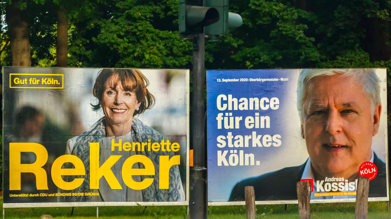 Wahlplakate von Henriette Reker (li.) und Andreas Kossiski stehen an einer Straße in Köln: Die Oberbürgermeisterin muss in die Stichwahl.