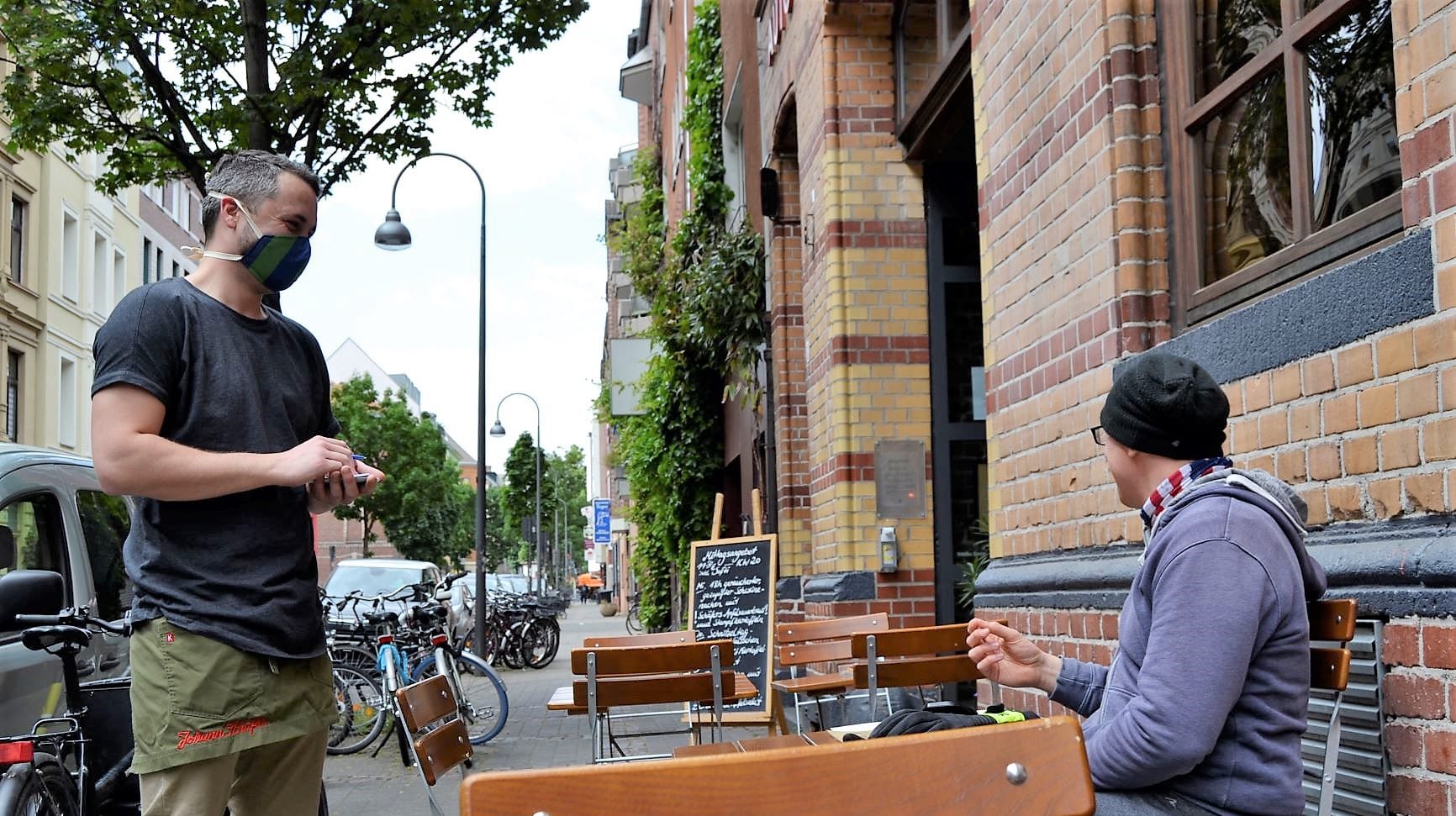 Im Brauhaus Schäfer bedient ein Kellner einen Gast: Noch können die Gäste draußen sitzen, doch wie es im Winter aussieht, das wissen die Kölner Gastronomen noch nicht.