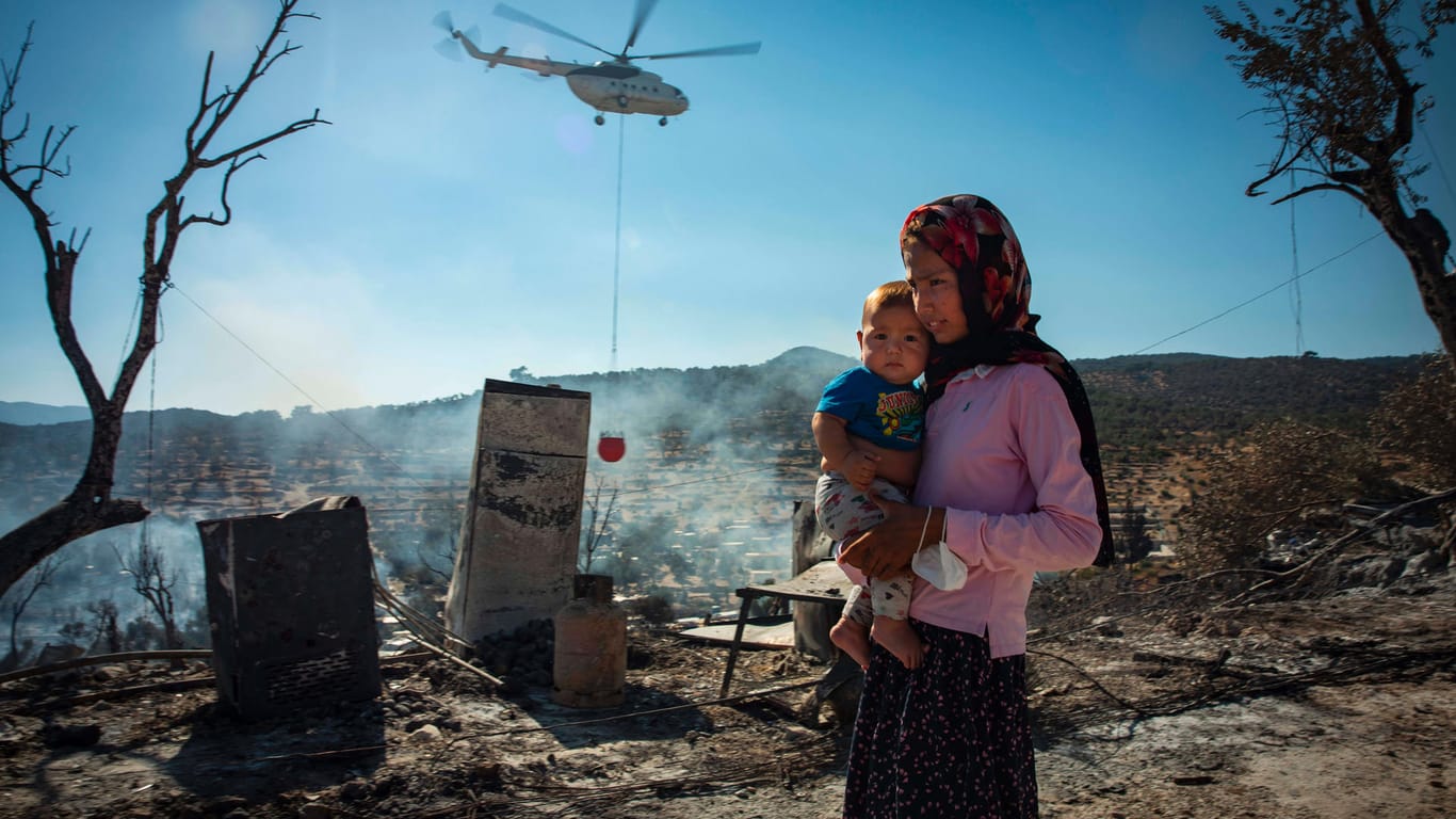 September auf Lesbos: Eine Frau und ihr Kind stehen nach dem Brand in den Baracken des Flüchtlingscamps.