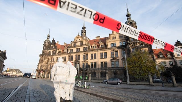 Zwei Mitarbeiter der Spurensicherung stehen vor dem Residenzschloss mit dem Grünen Gewölbe hinter einem Absperrband. Zwei Mitarbeiter der Spurensicherung stehen vor dem Residenzschloss mit dem Grünen Gewölbe hinter einem Absperrband.
