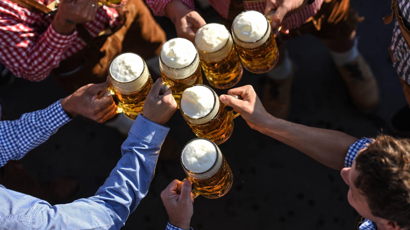 Oktoberfestbesucher stoßen miteinander an (Symbolbild): München verhängt Alkoholverbot auf der Theresienwiese.