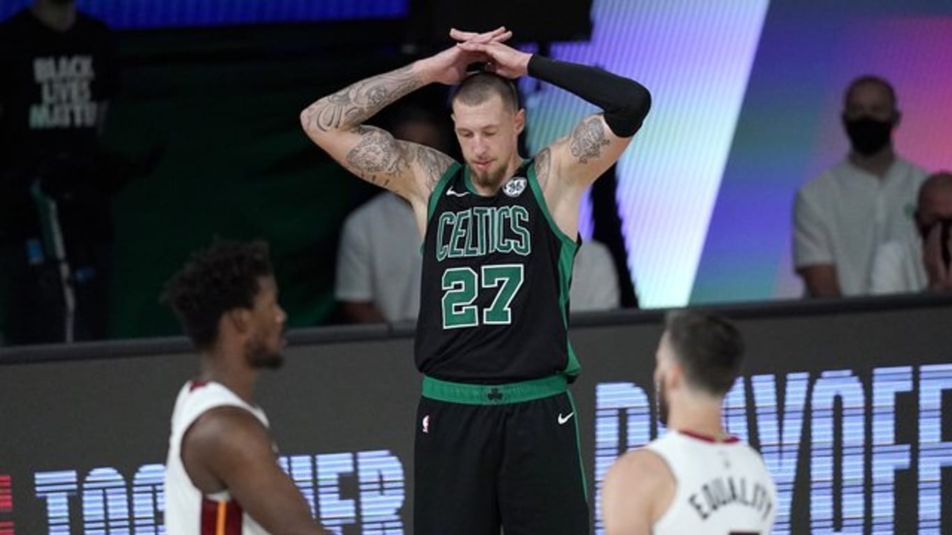 Daniel Theis (M) von den Boston Celtics legt die Hände über den Kopf und blickt zu Boden, während Jimmy Butler (l) und Goran Dragic von Miami Heat feiern.