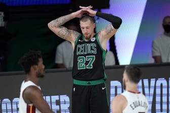 Daniel Theis (M) von den Boston Celtics legt die Hände über den Kopf und blickt zu Boden, während Jimmy Butler (l) und Goran Dragic von Miami Heat feiern.