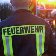 Feuerwehrleute stehen vor einem Einsatzwagen (Symbolbild): Ein Mann ist bei einem Brand in einer Erfurter Wohnung ums Leben gekommen.