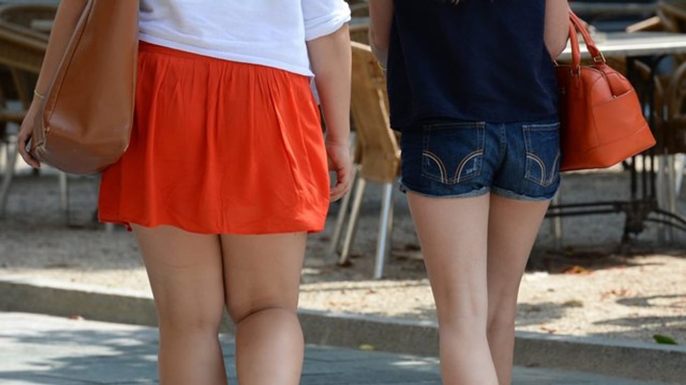 Junge Frauen in kurzen Röcken und Hotpants gehen durch die Innenstadt.