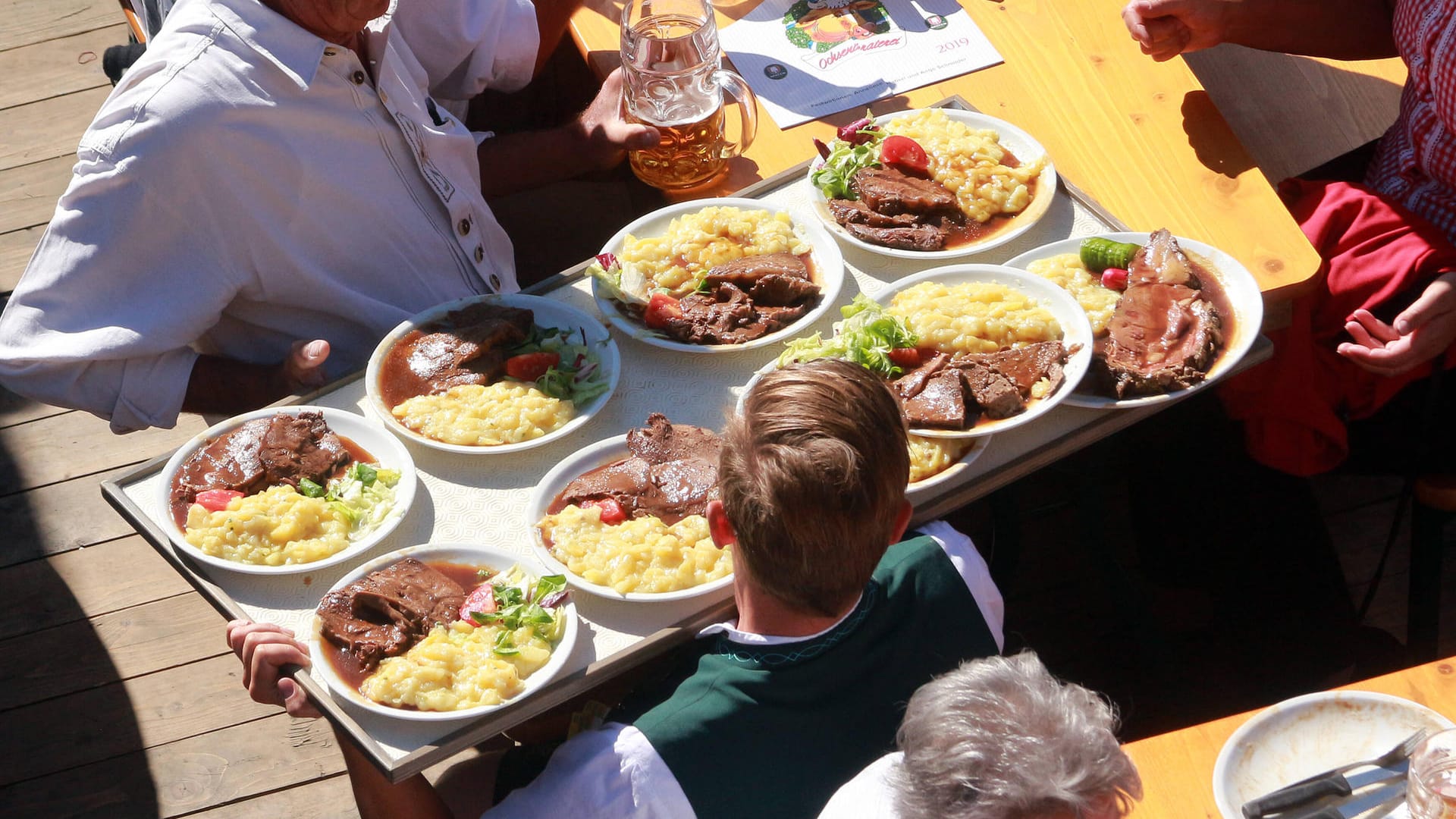 Ein Kellner balanciert ein volles Tablett (Archivbild): Auch kulinarisch hat das Oktoberfest einiges zu bieten.