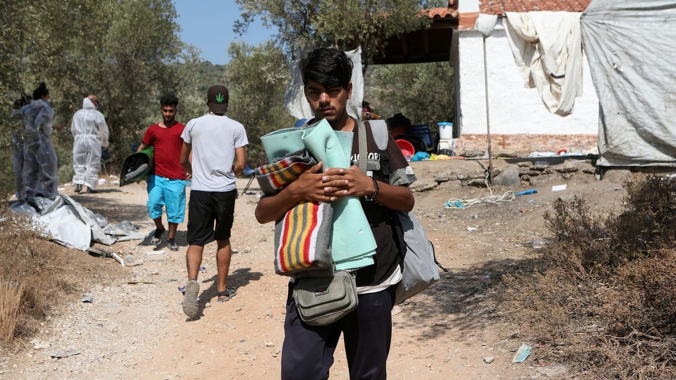 Lesbos: Migranten packen ihre wenigen Habseligkeiten, um in ein neues Lager umzuziehen.