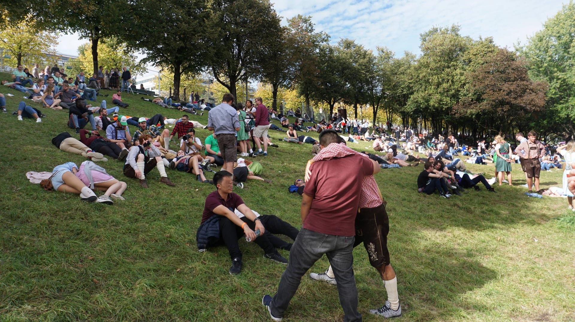 Menschen auf einem grünen Hügel: Der "Kotzhügel" trägt den Namen, den er zur Wiesn-Zeit hat, nicht umsonst.