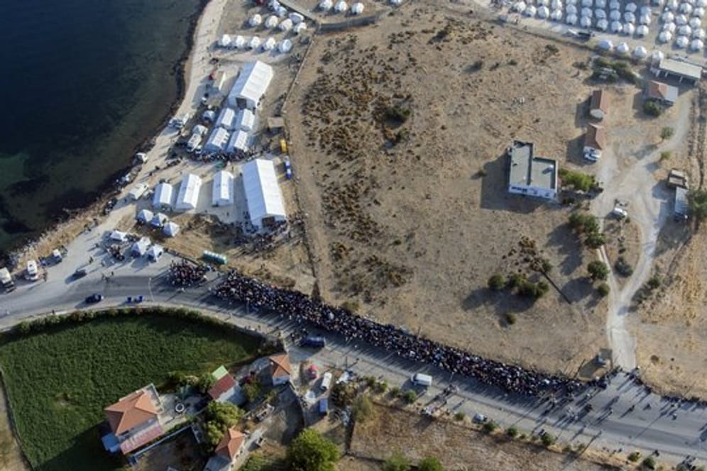 Eine größere Gruppe von Migranten wartet darauf, in das neue provisorische Flüchtlingslager gelassen zu werden.