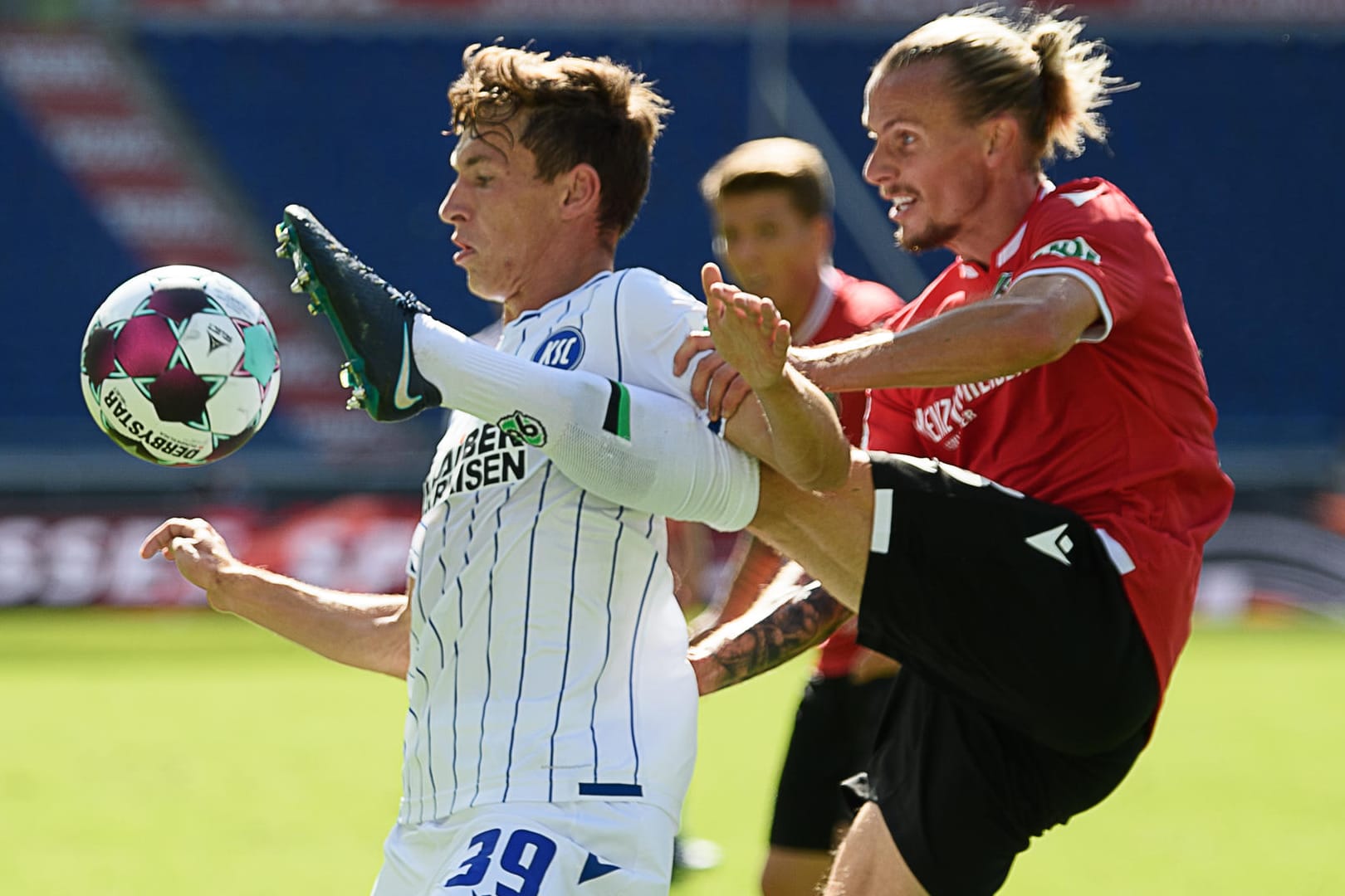 Stellvertretend für eine intensive Partie: Hannovers Niklas Hult (r.) im Zweikampf mit dem Karlsruher Benjamin Goller.