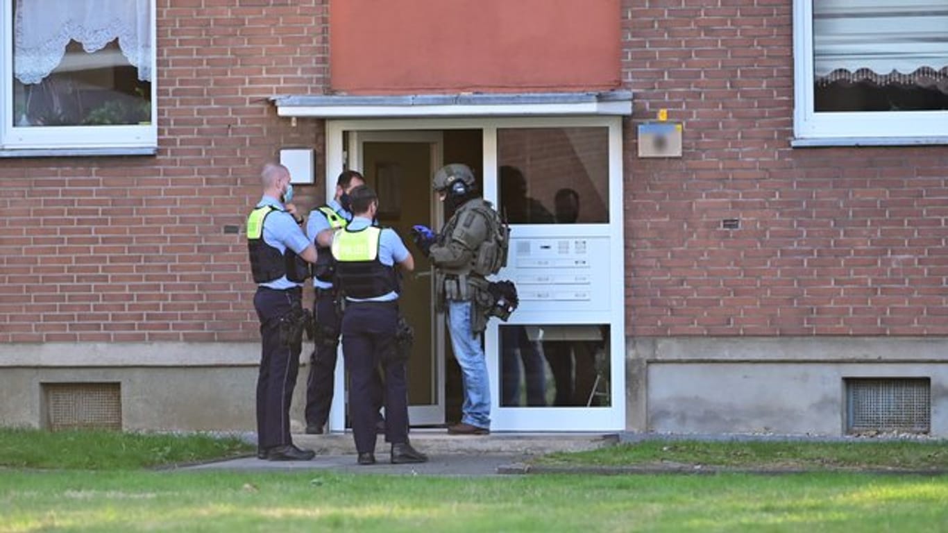 Polizei und ein SEK-Beamter stehen vor der Eingangstür eines Mehrfamilienhauses in krefeld.