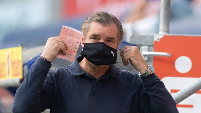 Michael Zorc, Sportdirektor von Borussia Dortmund, legt vorbildhaft einen Nase-Mund-Schutz an. Michael Zorc, Sportdirektor von Borussia Dortmund, legt vorbildhaft einen Nase-Mund-Schutz an.