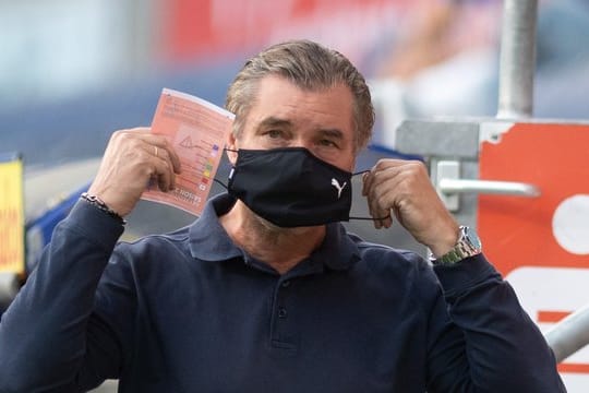 Michael Zorc, Sportdirektor von Borussia Dortmund, legt vorbildhaft einen Nase-Mund-Schutz an.