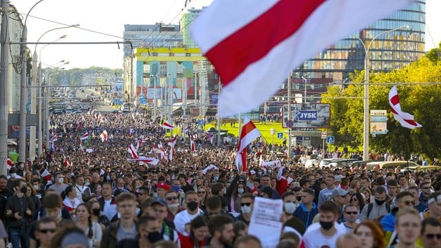 Demonstranten mit alten belarussischen Nationalflaggen gehen nach einer Kundgebung der Opposition durch Minsk, um gegen die offiziellen Ergebnisse der Präsidentschaftswahlen zu protestieren. Demonstranten mit alten belarussischen Nationalflaggen gehen nach einer Kundgebung der Opposition durch Minsk, um gegen die offiziellen Ergebnisse der Präsidentschaftswahlen zu protestieren.