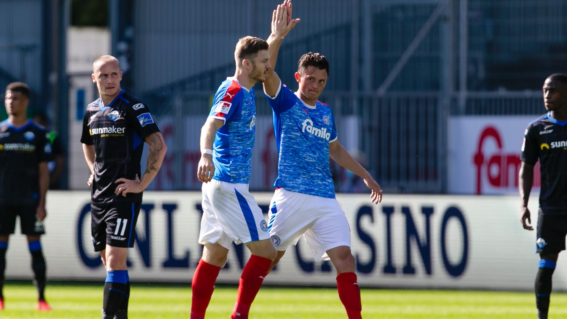 Kiels Mühling (M.) und Reese jubeln im Spiel gegen Paderborn.