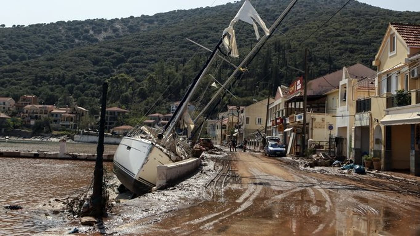 Eine Segelyacht liegt nach einem Sturm neben einer Straße in Kefalonia.