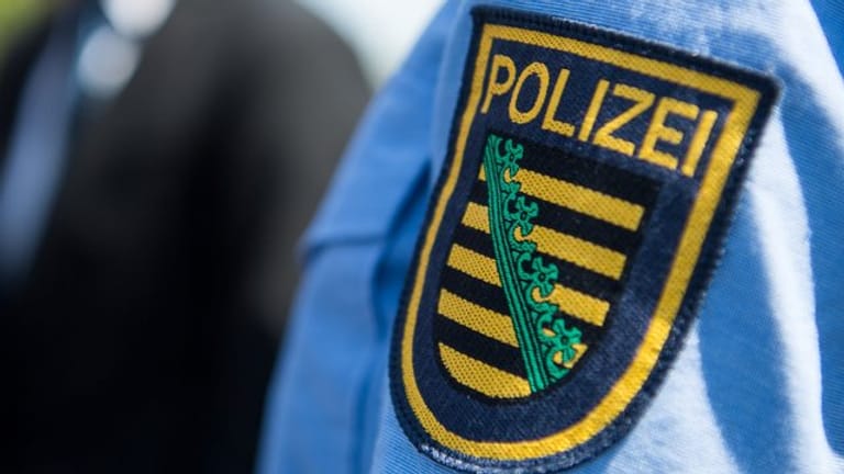 Das Logo der sächsischen Polizei: In Dresden hat ein Polizist einem Demonstranten mit dem Griff zur Waffe gedroht.